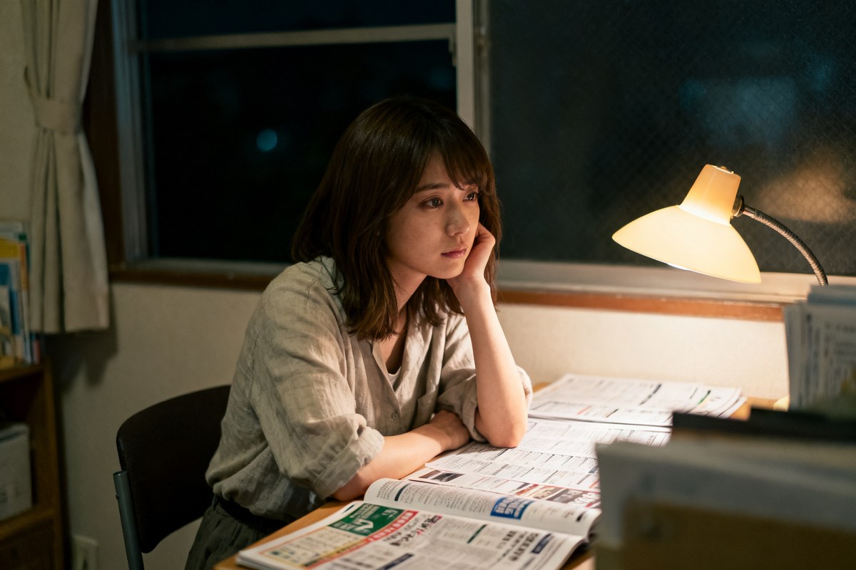 夜、机で求人情報を前に、辞めどきをひとりで考え込む女性