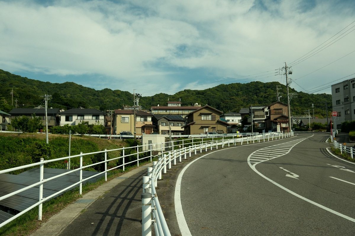 山あいの町へ向かって続く、ゆるやかなカーブの道
