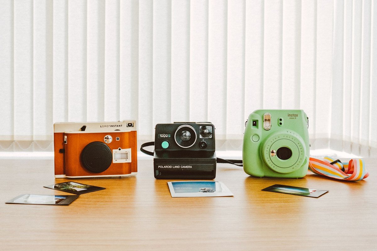 インスタントカメラと、撮った写真が並ぶテーブル